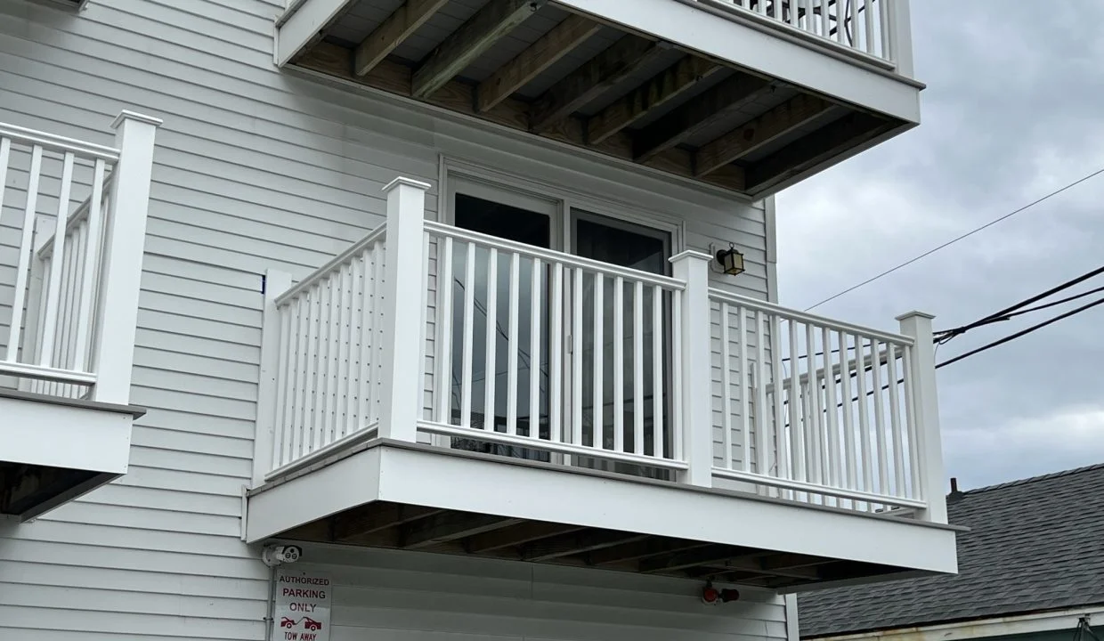 a white house with a white balcony and balconies.