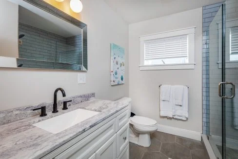 a bathroom with a sink, toilet, and shower.