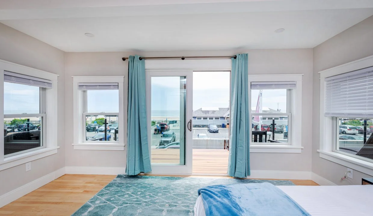 a bedroom with a large bed and two windows.