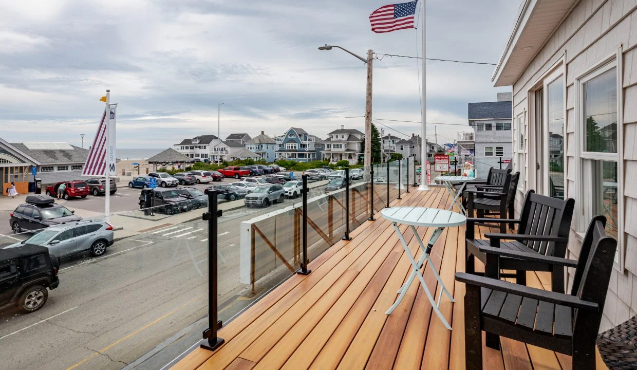 a wooden deck with chairs and a table on it.