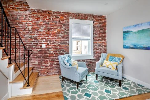 a living room with two chairs and a rug.