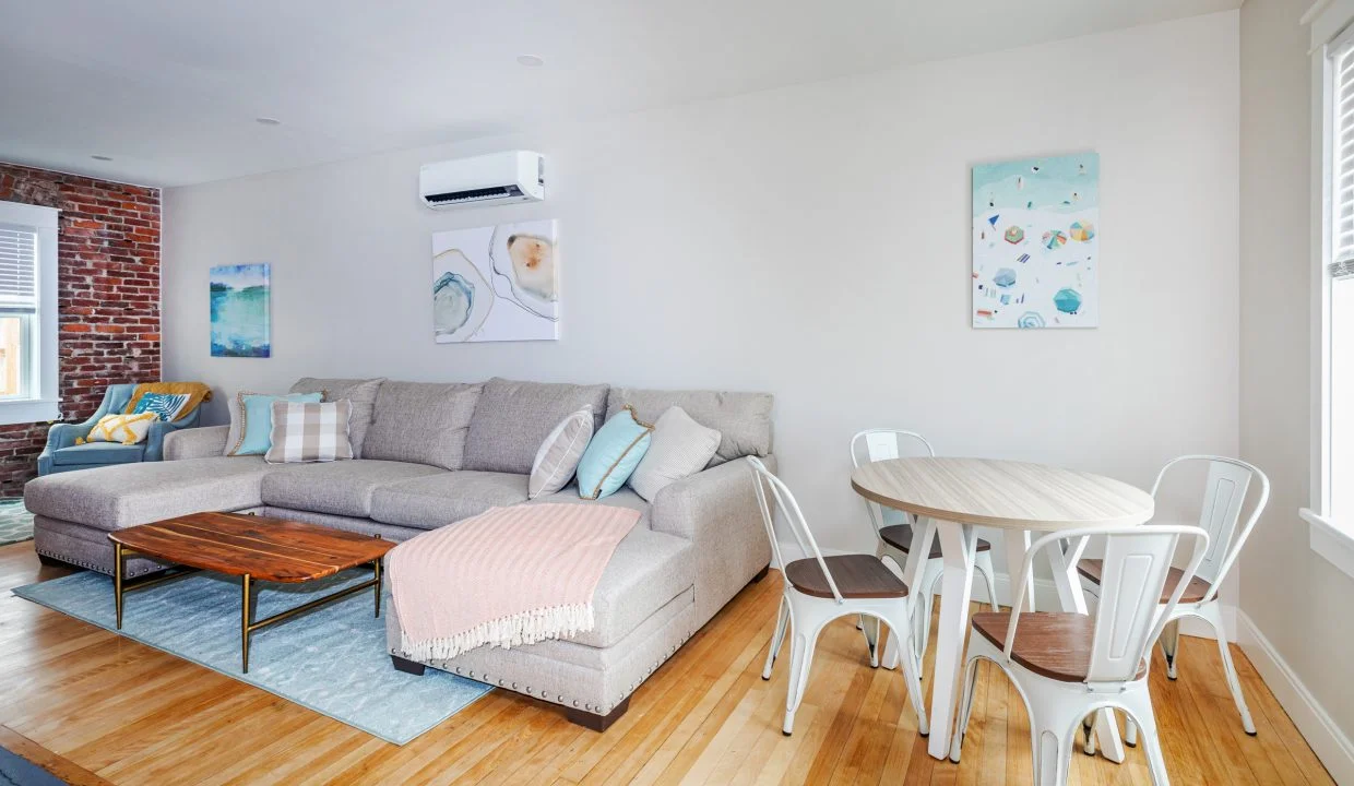 a living room filled with furniture and a wooden floor.