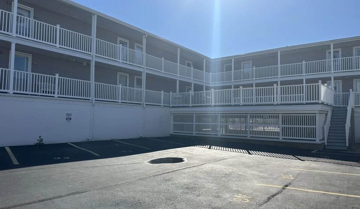 an empty parking lot in front of an apartment building.