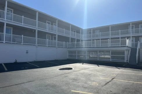 an empty parking lot in front of an apartment building.