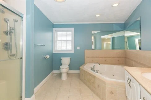 a bathroom with a tub, toilet and sink.