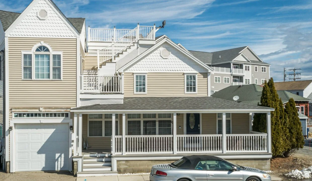 a car parked in front of a two story house.