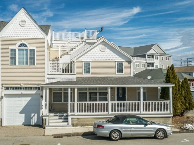 a car parked in front of a two story house.