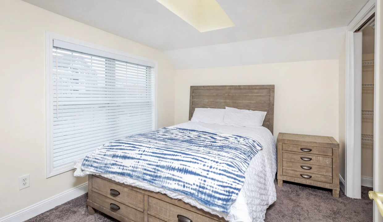 a bed sitting in a bedroom next to a window.