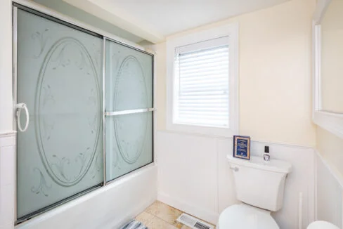 a bathroom with a toilet and a glass shower door.