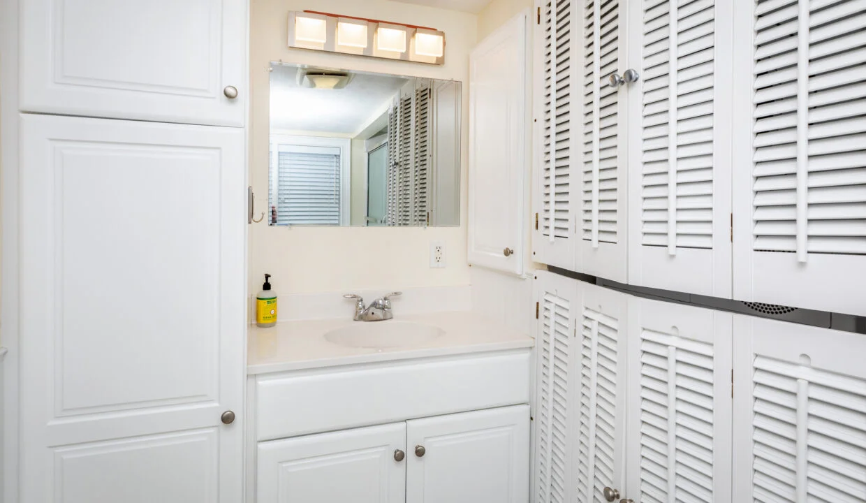 a bathroom with white cabinets and a sink.