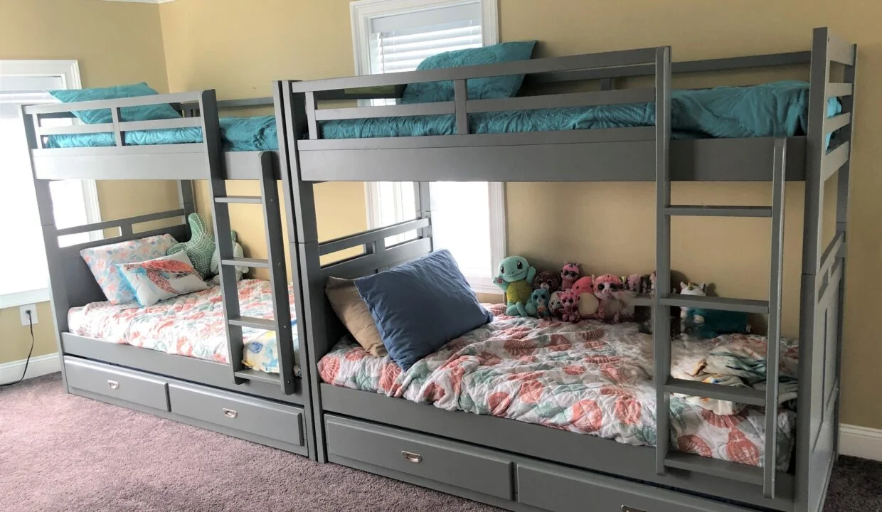 a room with three bunk beds and a stuffed animal.