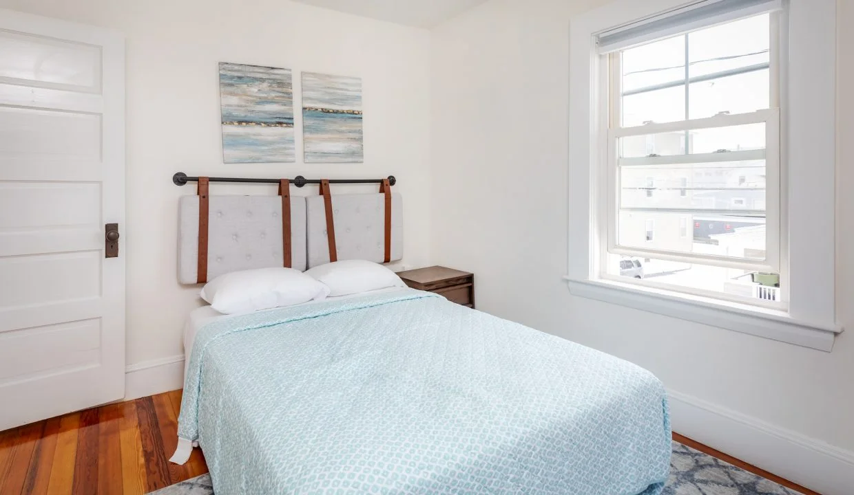 a small bedroom with a bed and a window.