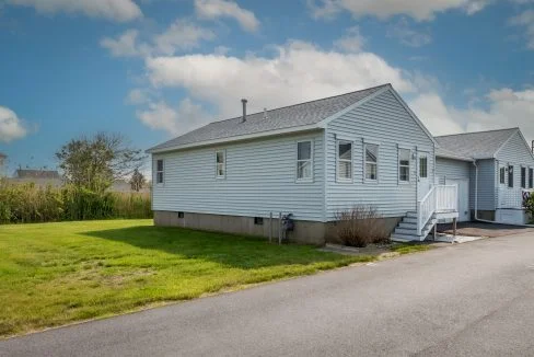 a white house sitting on the side of a road.