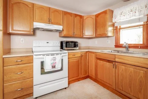 a kitchen with wooden cabinets and white appliances.