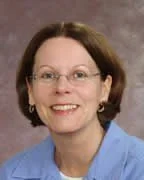 A woman wearing glasses and a blue shirt.