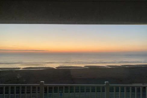 Sunset view over a beach from a balcony.