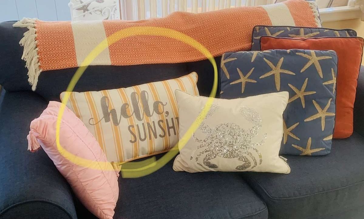 A navy blue couch with multiple decorative pillows, including one that says 